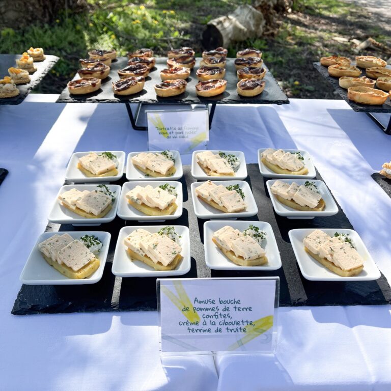 Buffet zéro déchet en extérieur dressé par La Cuisine de Demain à Strasbourg : tartelettes et amuse-bouches sur ardoise avec étiquettes manuscrites