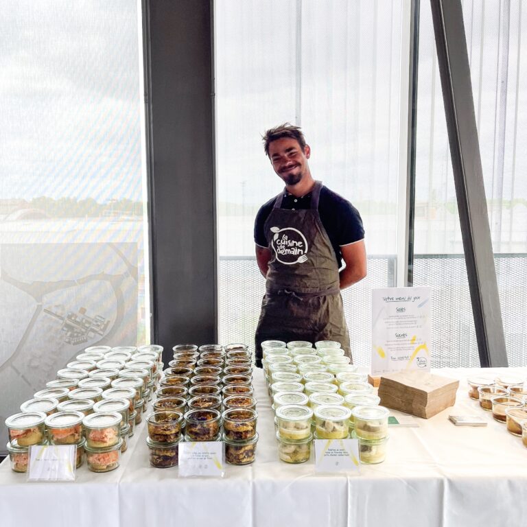Chef de La Cuisine de Demain, traiteur local à Strasbourg, devant son buffet en bocaux préparé pour un événement d'entreprise
